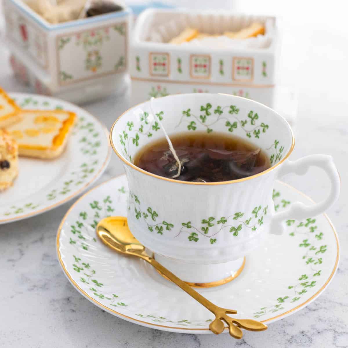 A cup of tea with a little golden spoon on the saucer.