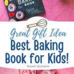 A copy of The Ultimate Kids' Baking Book on a pink table with bowls of frosting and sprinkles.