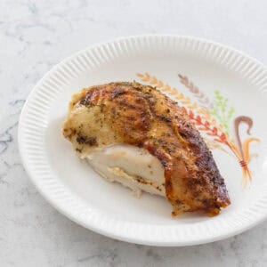 A slice of the roasted turkey is on a fall plate.