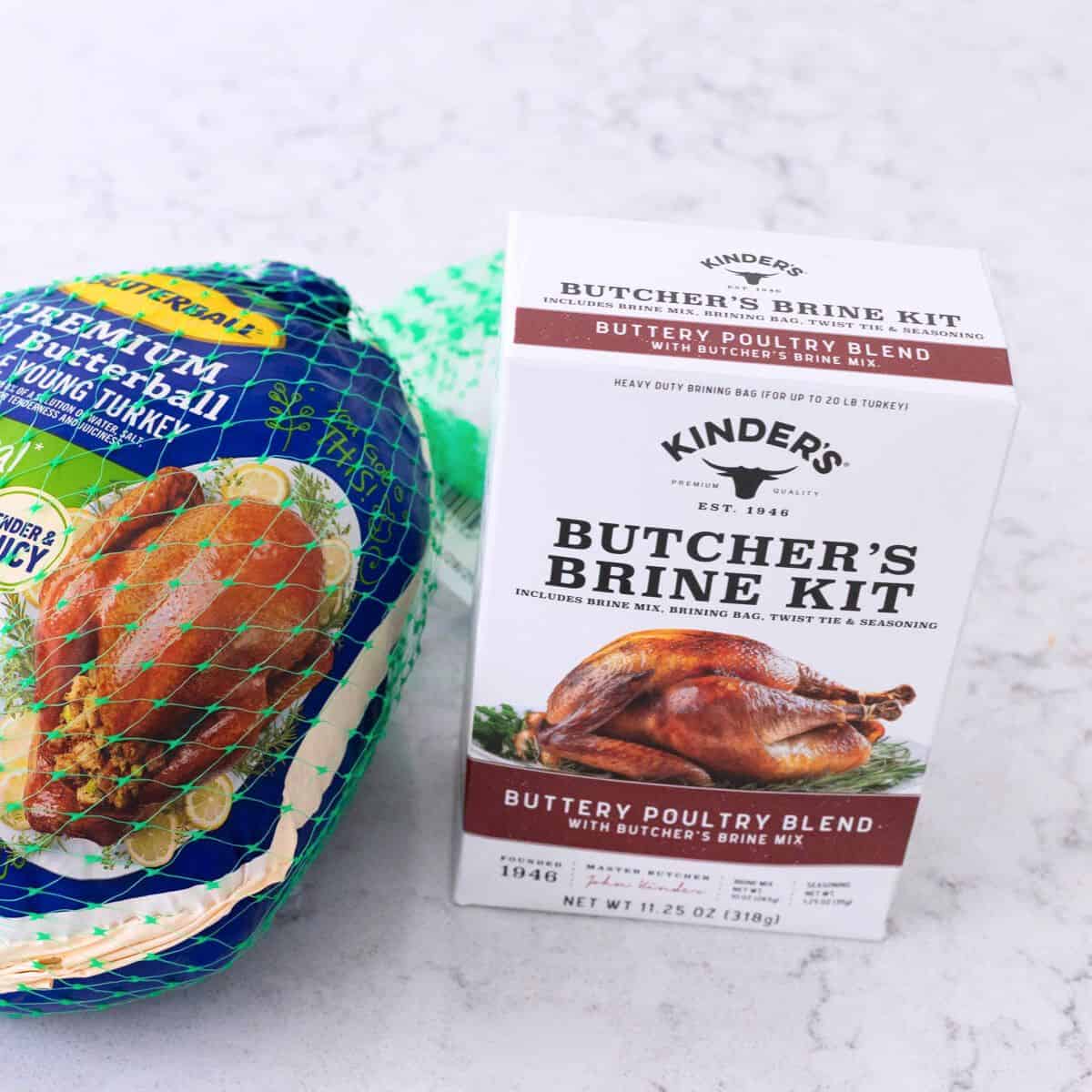 The box of Kinder's Turkey Brine Kit seasonings is on the counter next to a whole turkey.