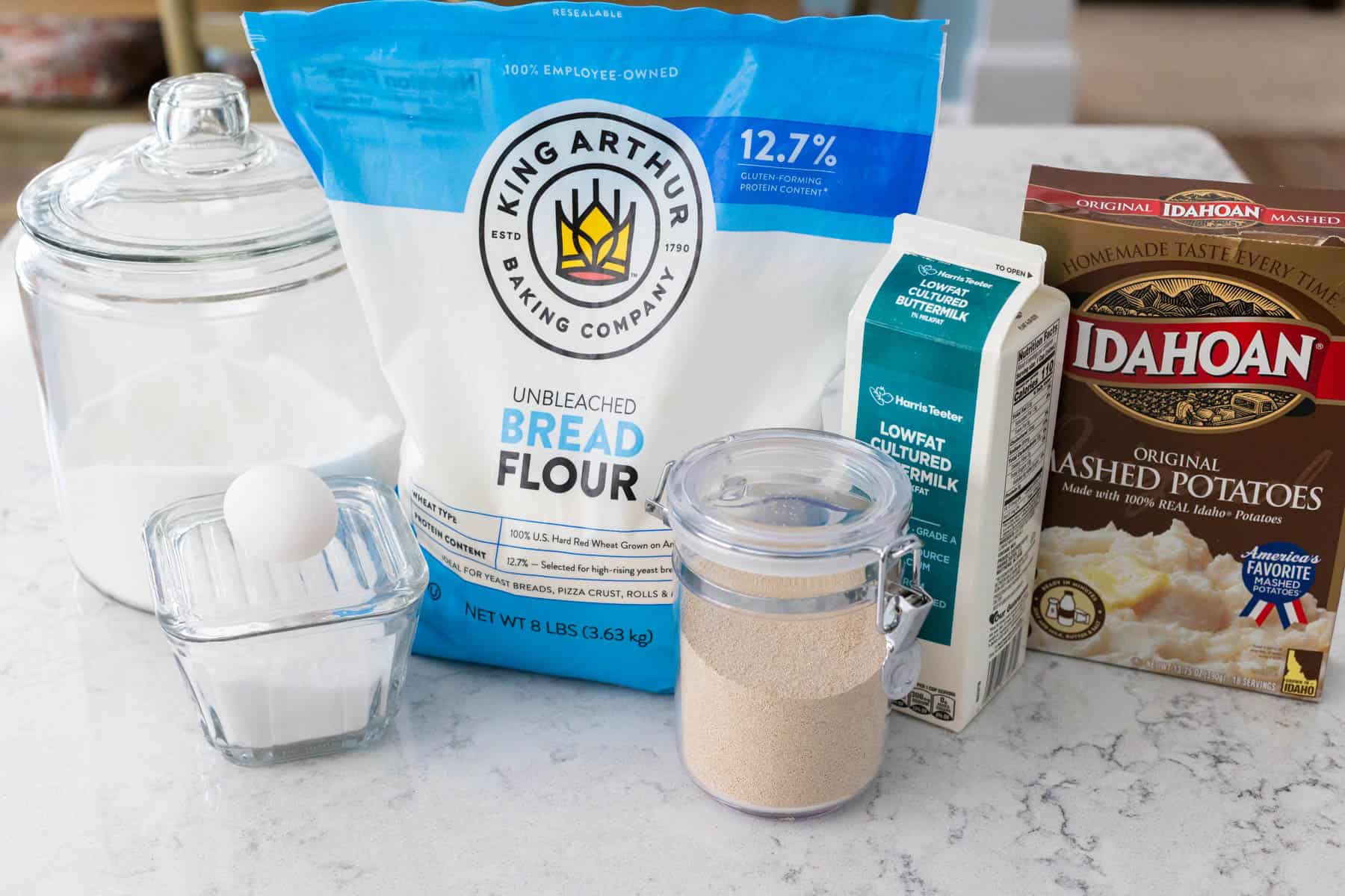 The ingredients to make potato rolls in a bread machine are on the counter.