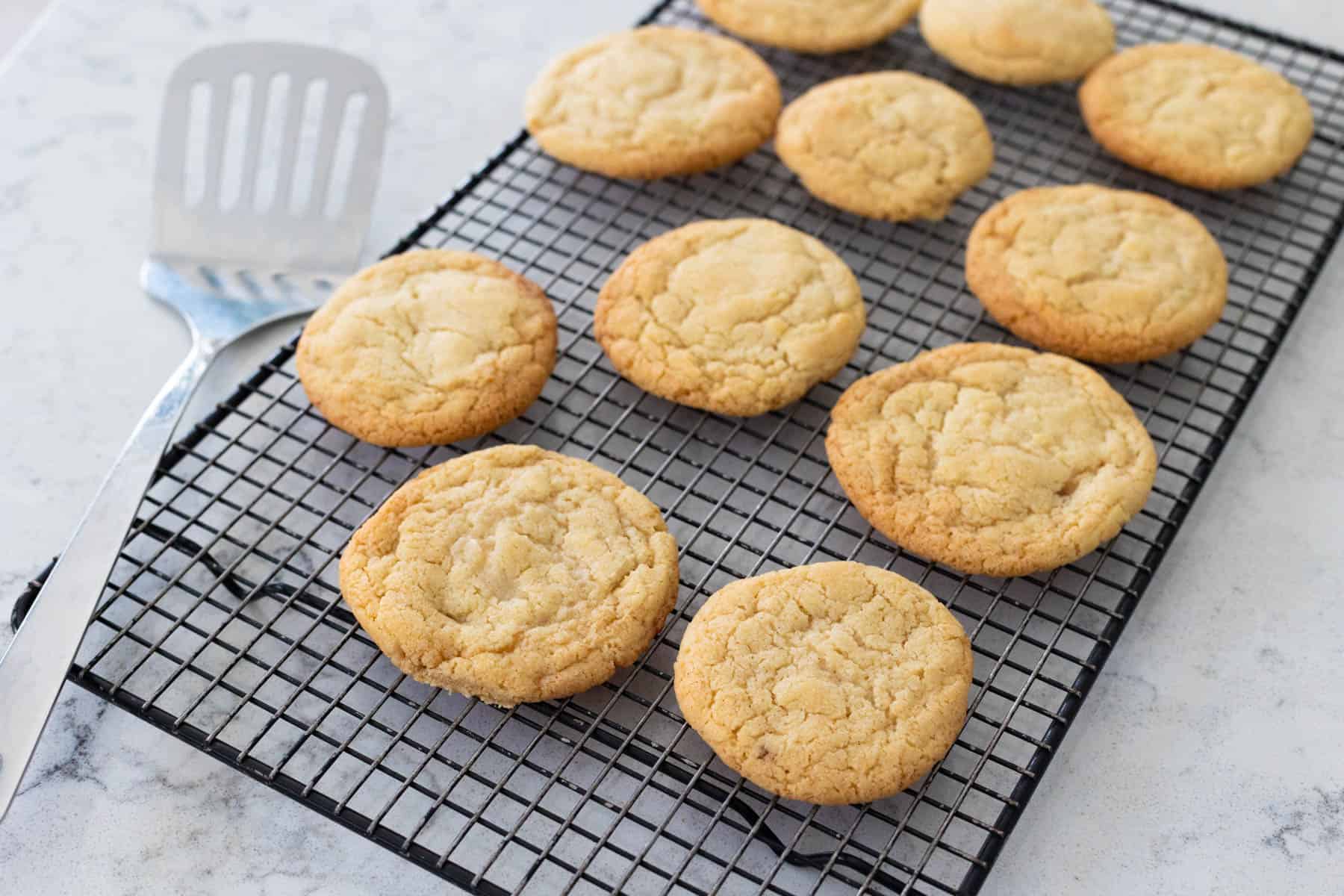Des biscuits à la vanille fraîchement cuits refroidissant sur une grille.