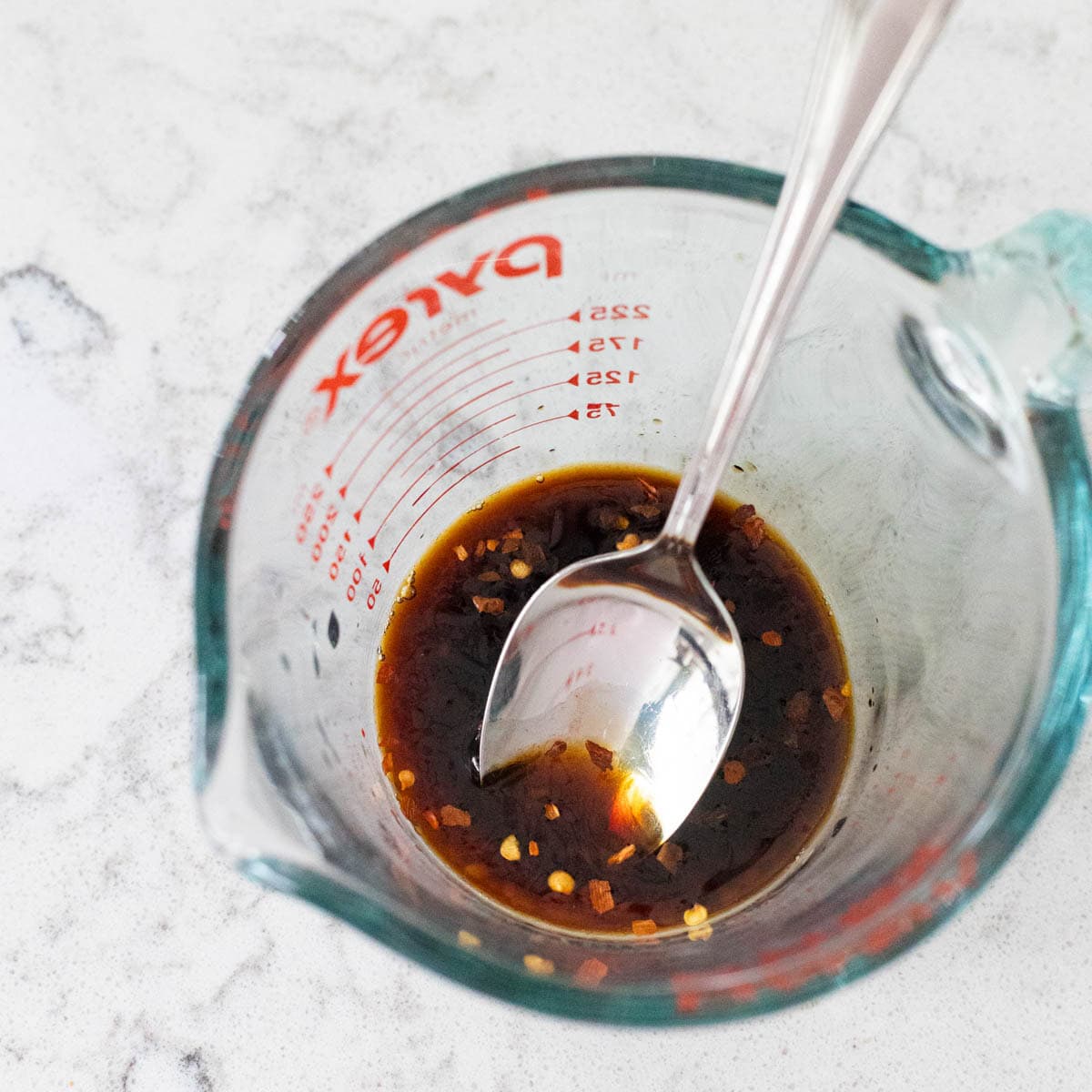 The measuring cup is filled with the potsticker sauce.