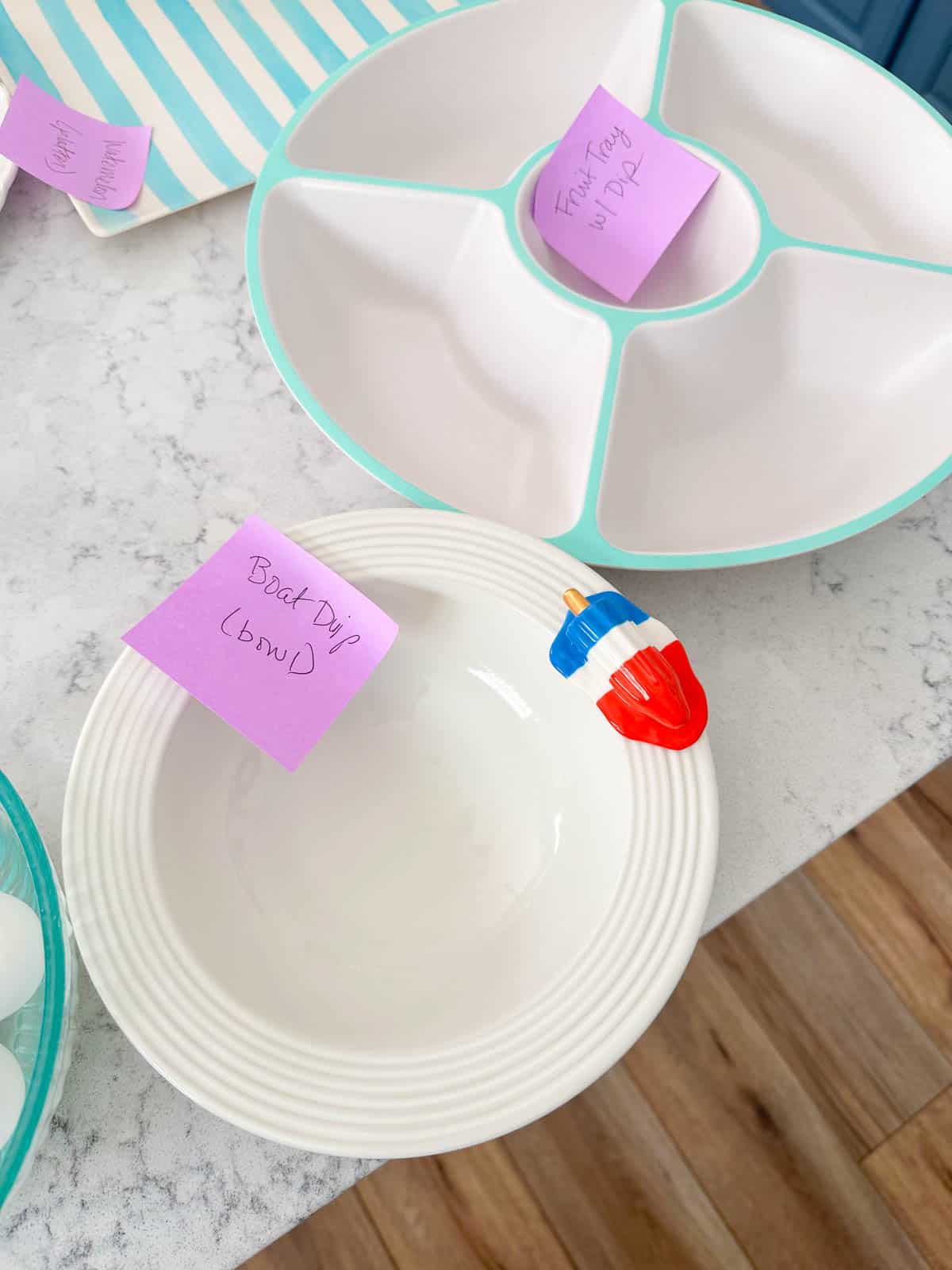Empty serving dishes with post-it notes marking what will be served inside.