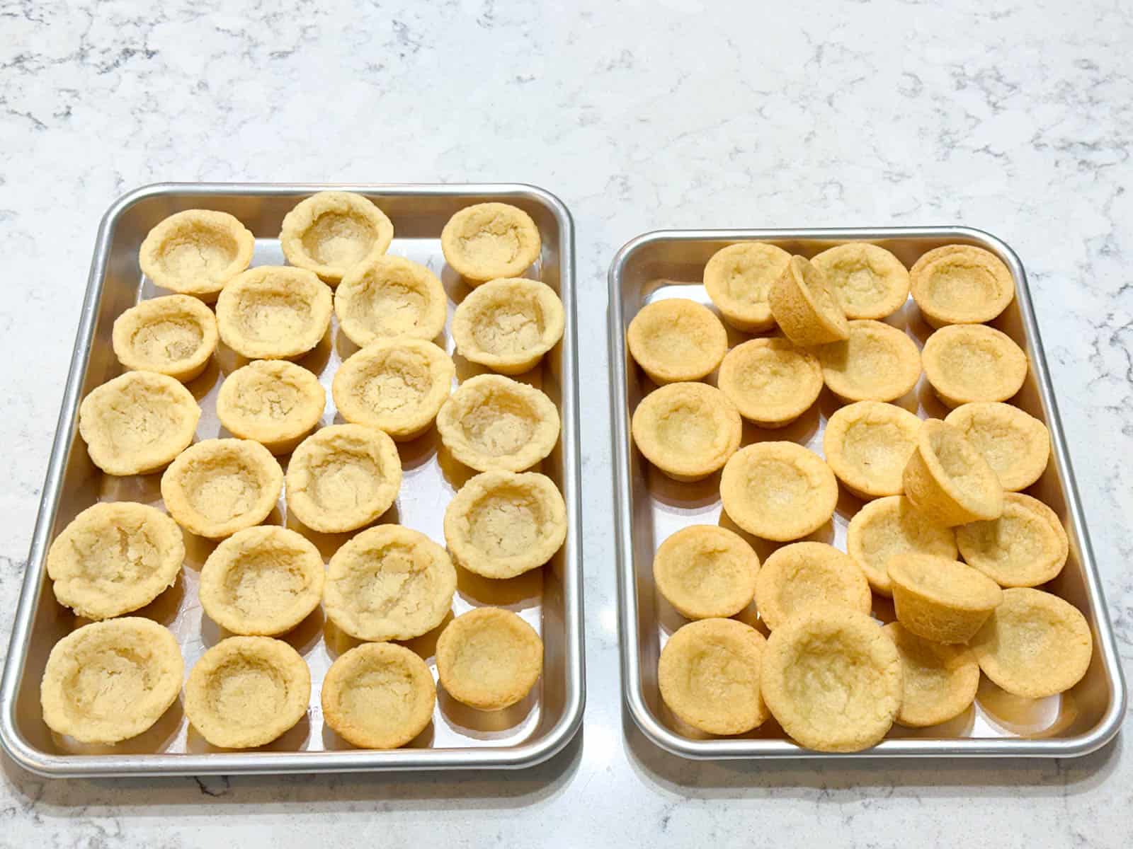 The baking pans are filled with empty sugar cookie cups.