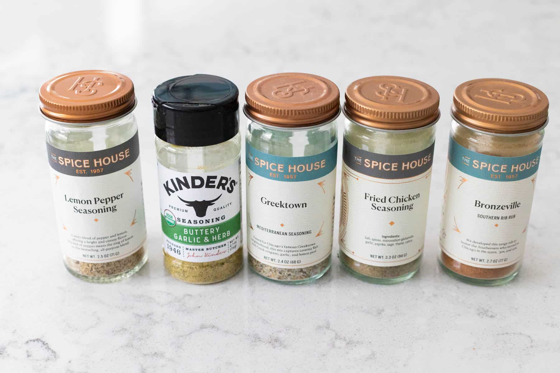 A row of seasoning jars that pair well with baked chicken.