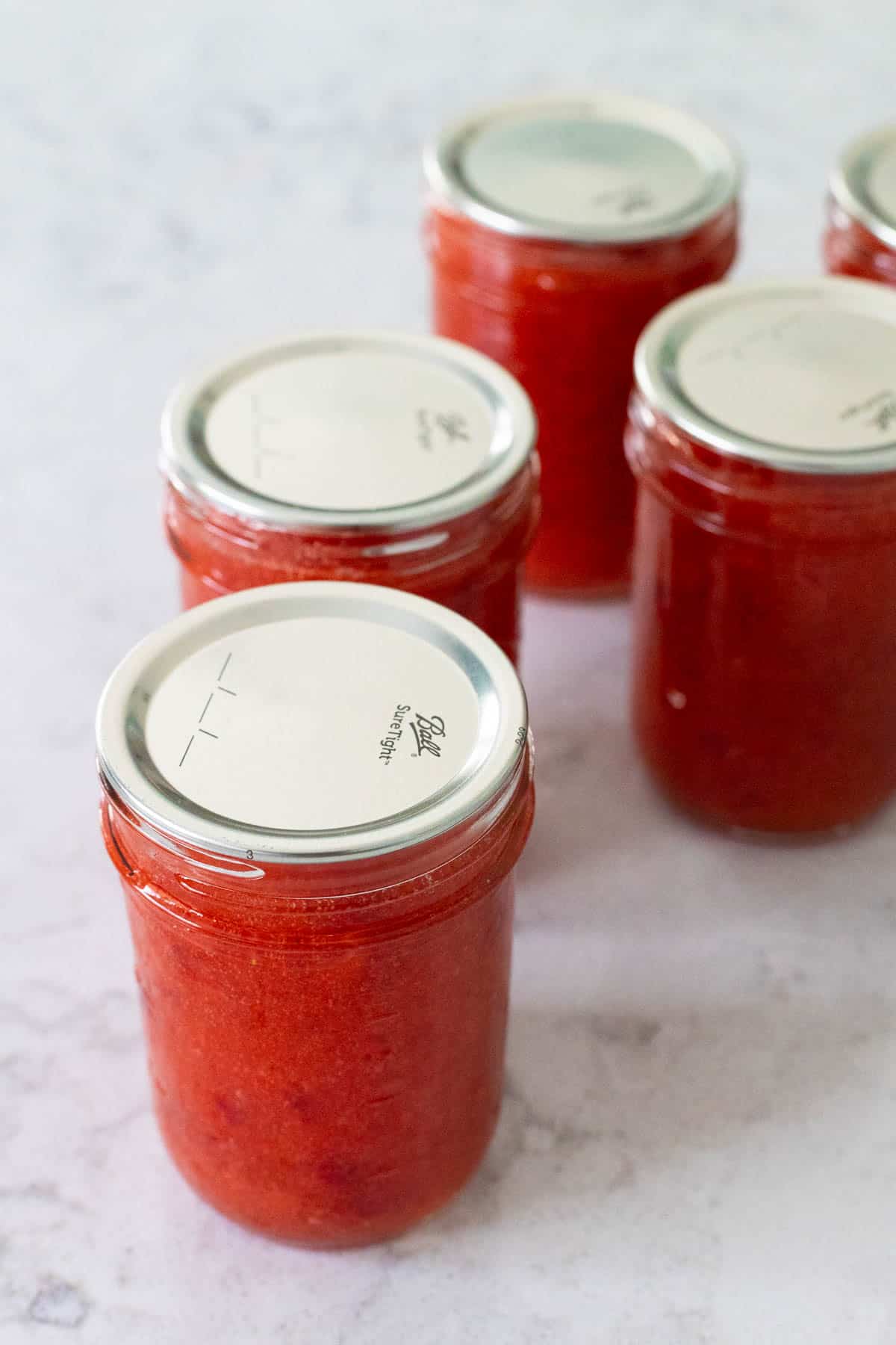 The jam jars have their metal lids in place.