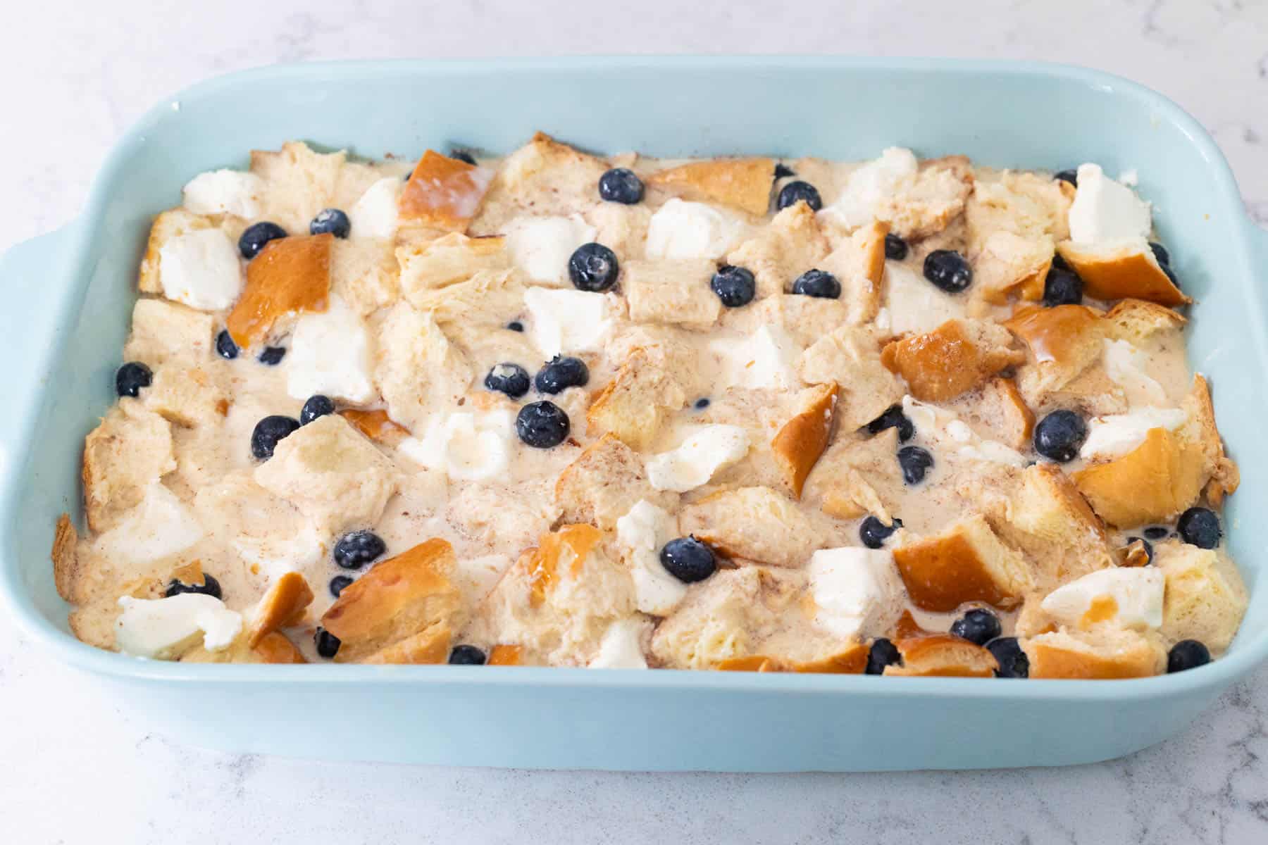The bread pudding is soaking in the egg custard.