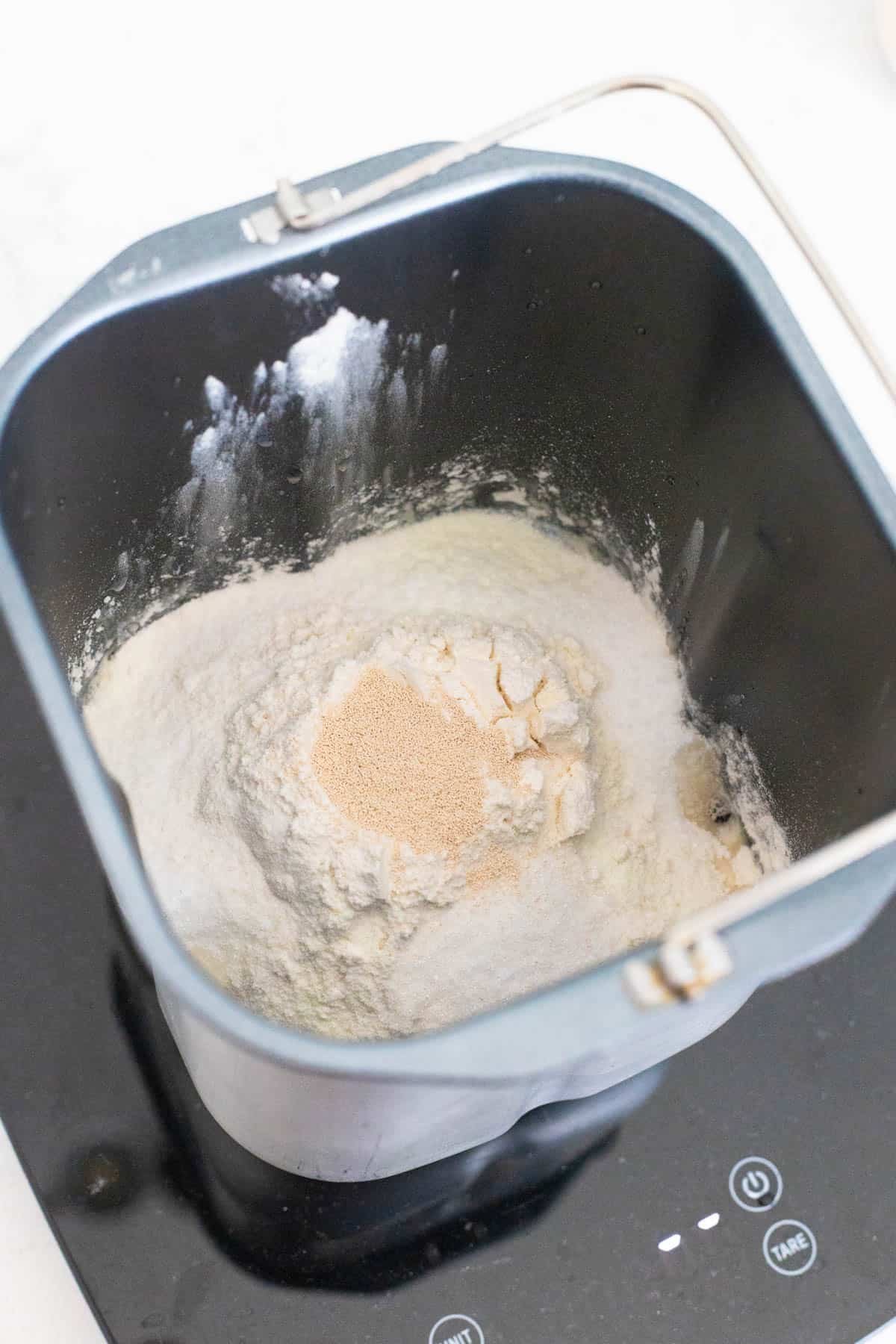 All of the ingredients have been added to the bread pan. The yeast is in a well in the flour on top.
