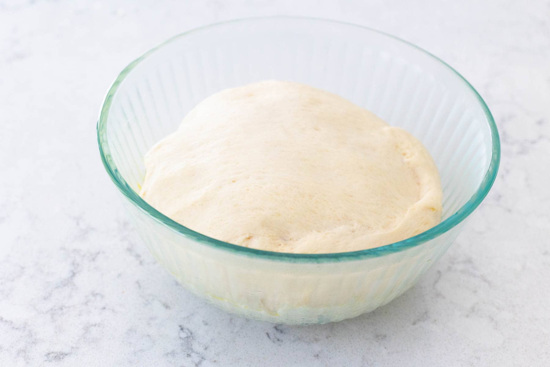 The finished dough is ready to use for baking and is resting in a large mixing bowl.