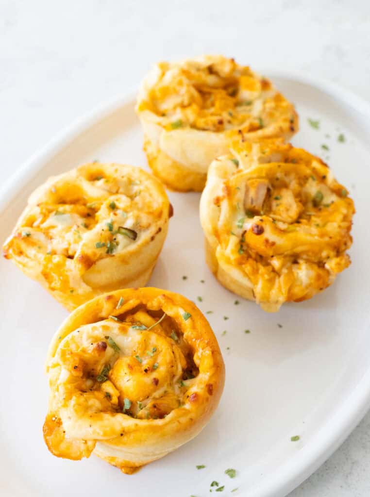 The buffalo chicken rolls are served on a white platter.