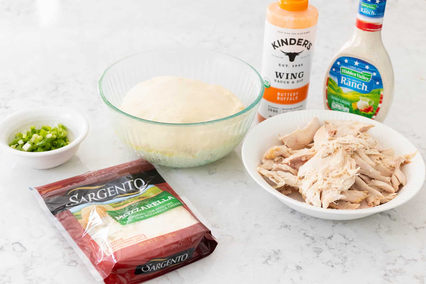 The ingredients to make the homemade buffalo chicken rolls are on the kitchen counter.