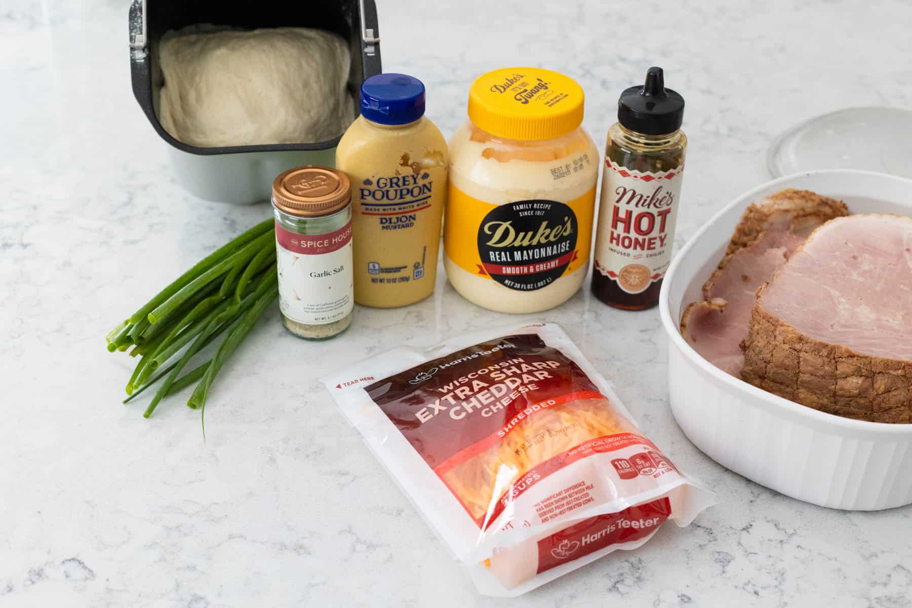 The ingredients to make homemade ham and cheese rolls are on the kitchen counter.