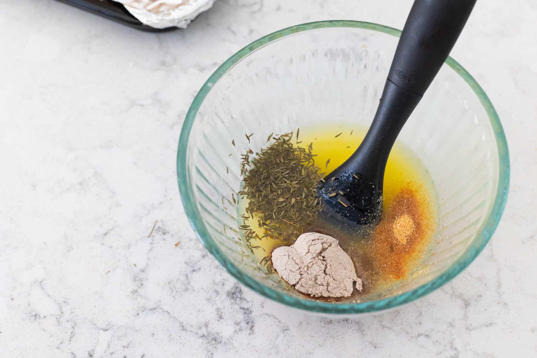 The melted butter and seasonings are being mixed together in a small bowl. 