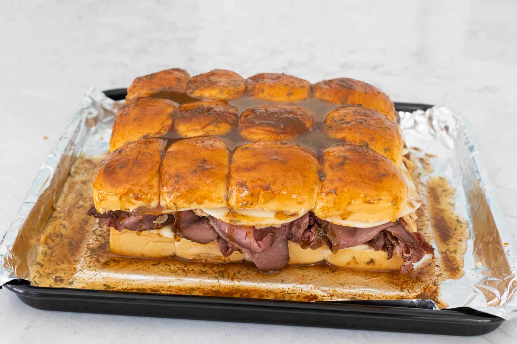 The assembled sliders have been brushed with melted butter and seasonings. 