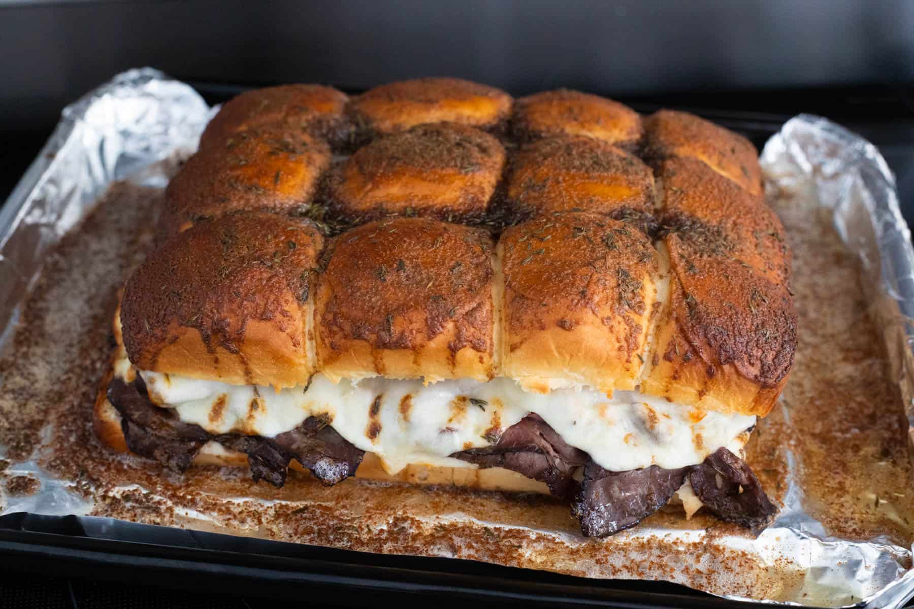 The baking pan filled with French dip sliders has just come out of the oven. 